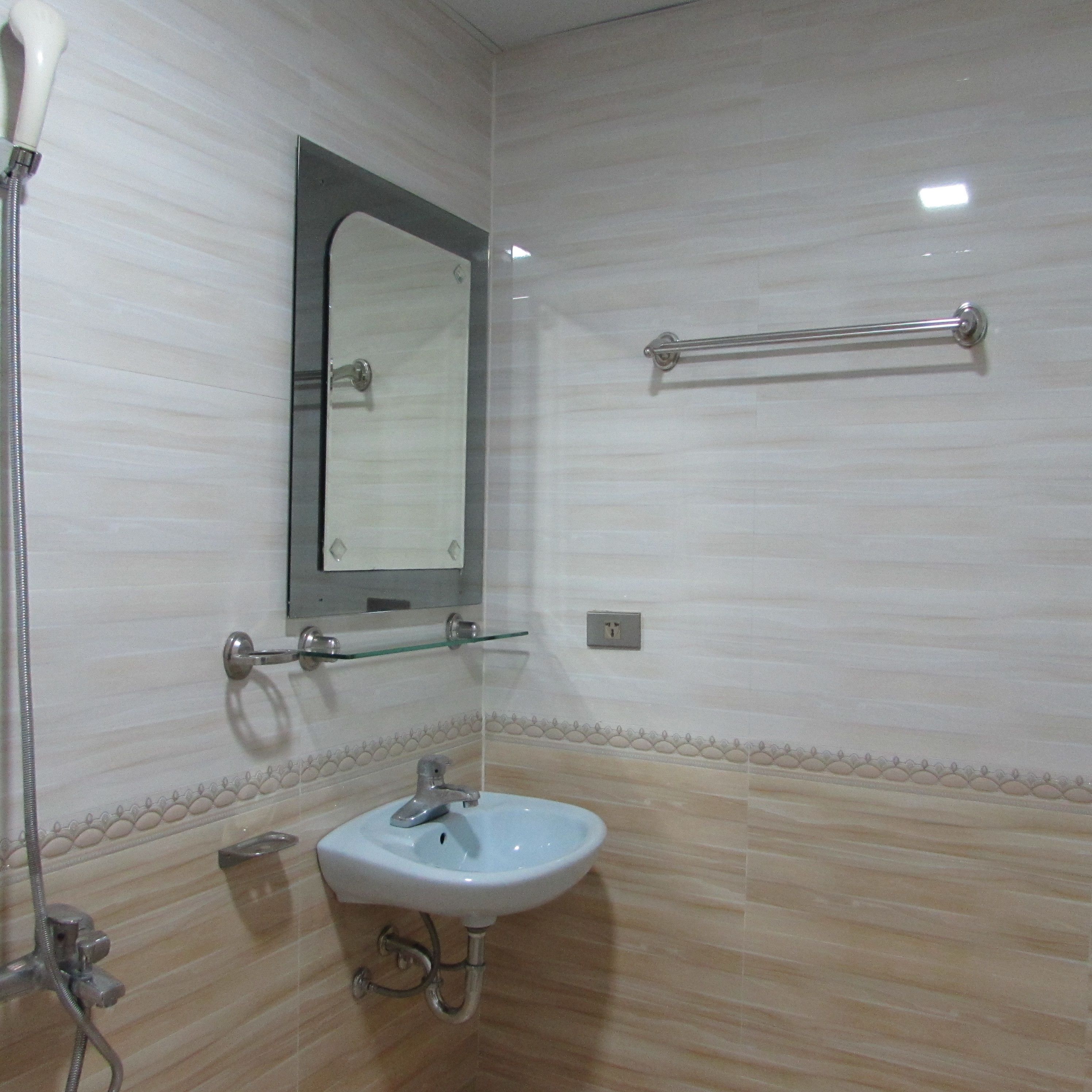 A bathroom with a sink, mirror, towel rack, and shower.