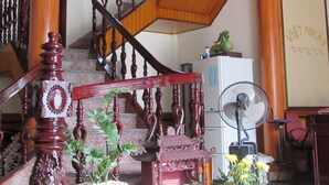 A staircase with wooden railings and a fan in the room. - Viet Nhat Halong Hotel (Bai Chay)
