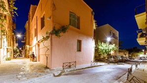 Una calle estrecha flanqueada por edificios, con una scooter estacionada y una señal de parada.