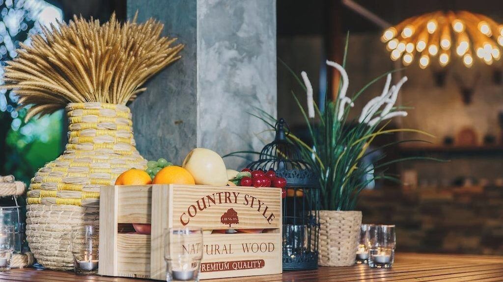 A wooden crate labeled "COUNTRY STYLE" with fruits and a woven basket.