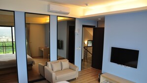 A hotel room with a bed, a sofa, a TV, and a view of the city. - One City One Vacation Farm (Nantou)