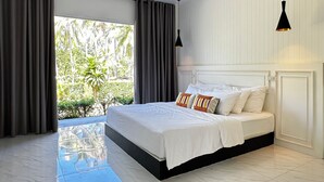 A modern bedroom with a large bed, a view of greenery outside, and a balcony. - Koh Kood BED's (Ko Kood)