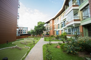 Un patio con un sendero empedrado, césped verde y diversas plantas.