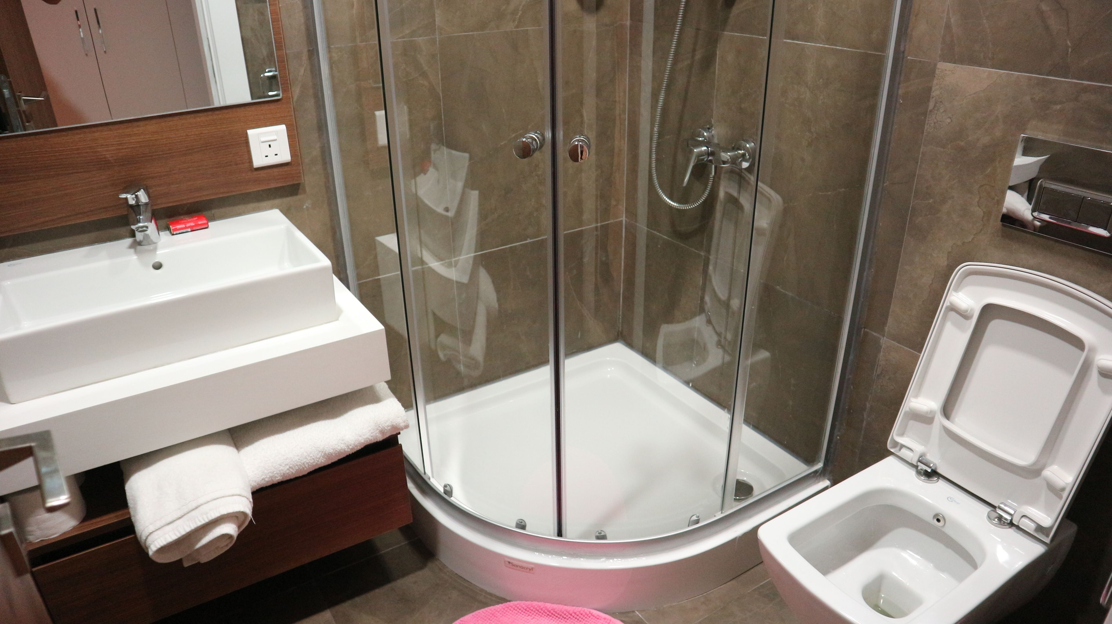 Une salle de bain avec douche, toilettes et lavabo.