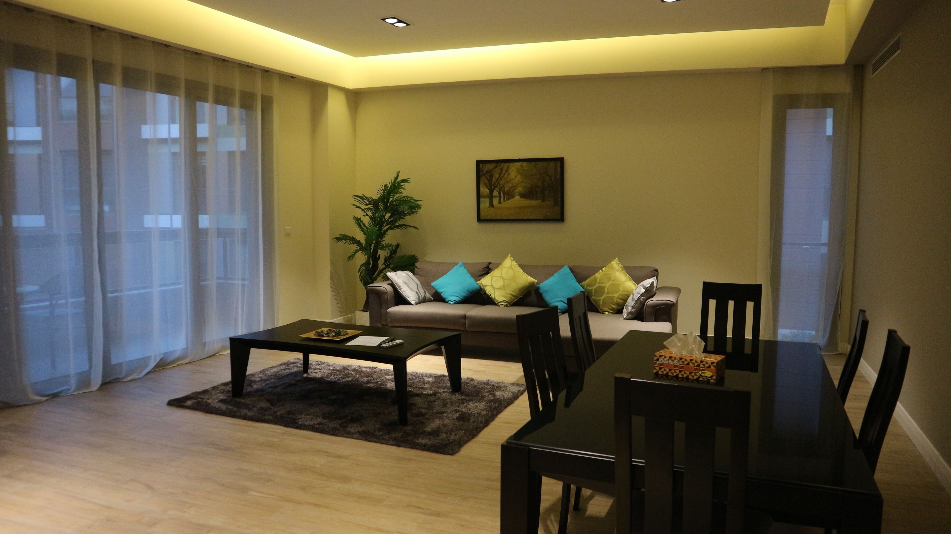 A modern living room with a sofa, coffee table, and dining table.