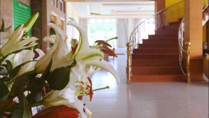 A hotel lobby with a staircase, a reception desk, and a large window. - Ativara Hotels And Resorts (Nyaungshwe)