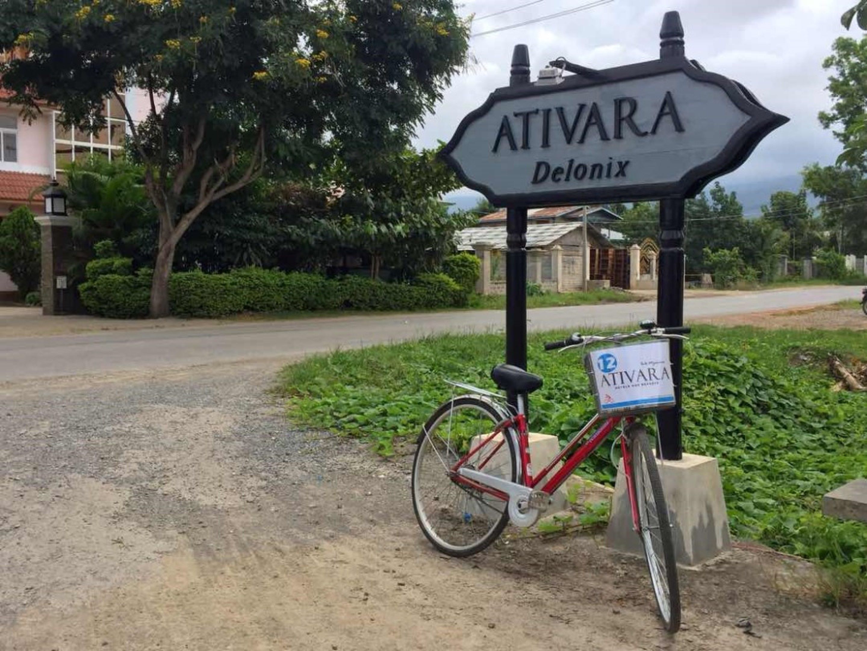 Naamplaatje voor Ativara Delonix, met een fiets die er staat geparkeerd.