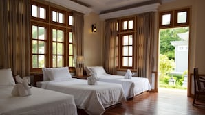 A hotel room with three beds, wooden flooring, large windows, and a view of greenery outside. - Ativara Hotels And Resorts (Nyaungshwe)