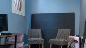 A room with two patterned chairs, a pink chair, a desk, and a large dark headboard. - Maison Brunetti (Rome)