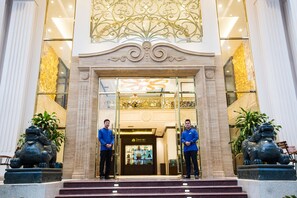 A grand entrance with two men standing in front, flanked by statues of lions. - Song Loc Luxury (Bai Chay)