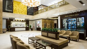 A spacious lobby with a reception desk, seating area, and a jewelry shop. - Song Loc Luxury (Bai Chay)