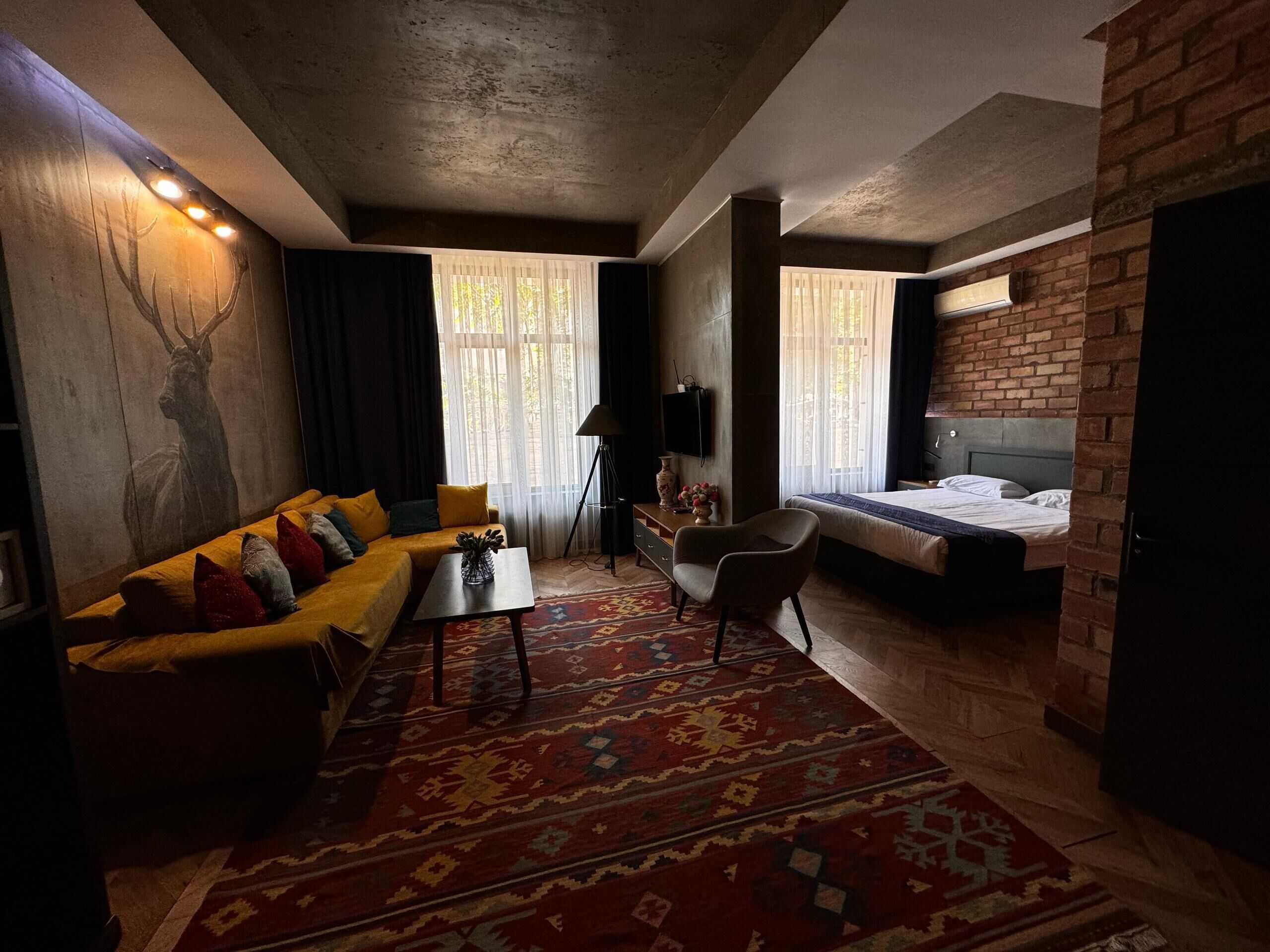 Ein modernes Zimmer mit einer Couch, einem kleinen Tisch, einem Bett und einem Fernseher.
