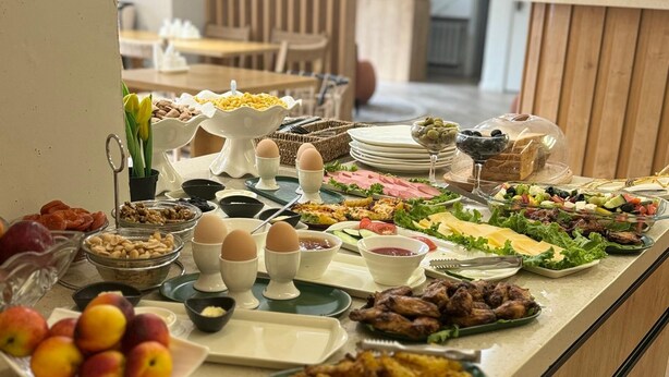 A buffet with various food items including fruits, eggs, salads, and meats. - Bugu Hotel (Bishkek)