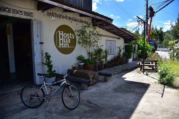 A building with a sign reading "Host's Inn" and a bicycle parked outside. - Hosts Huahin - Hostel (Hua Hin)