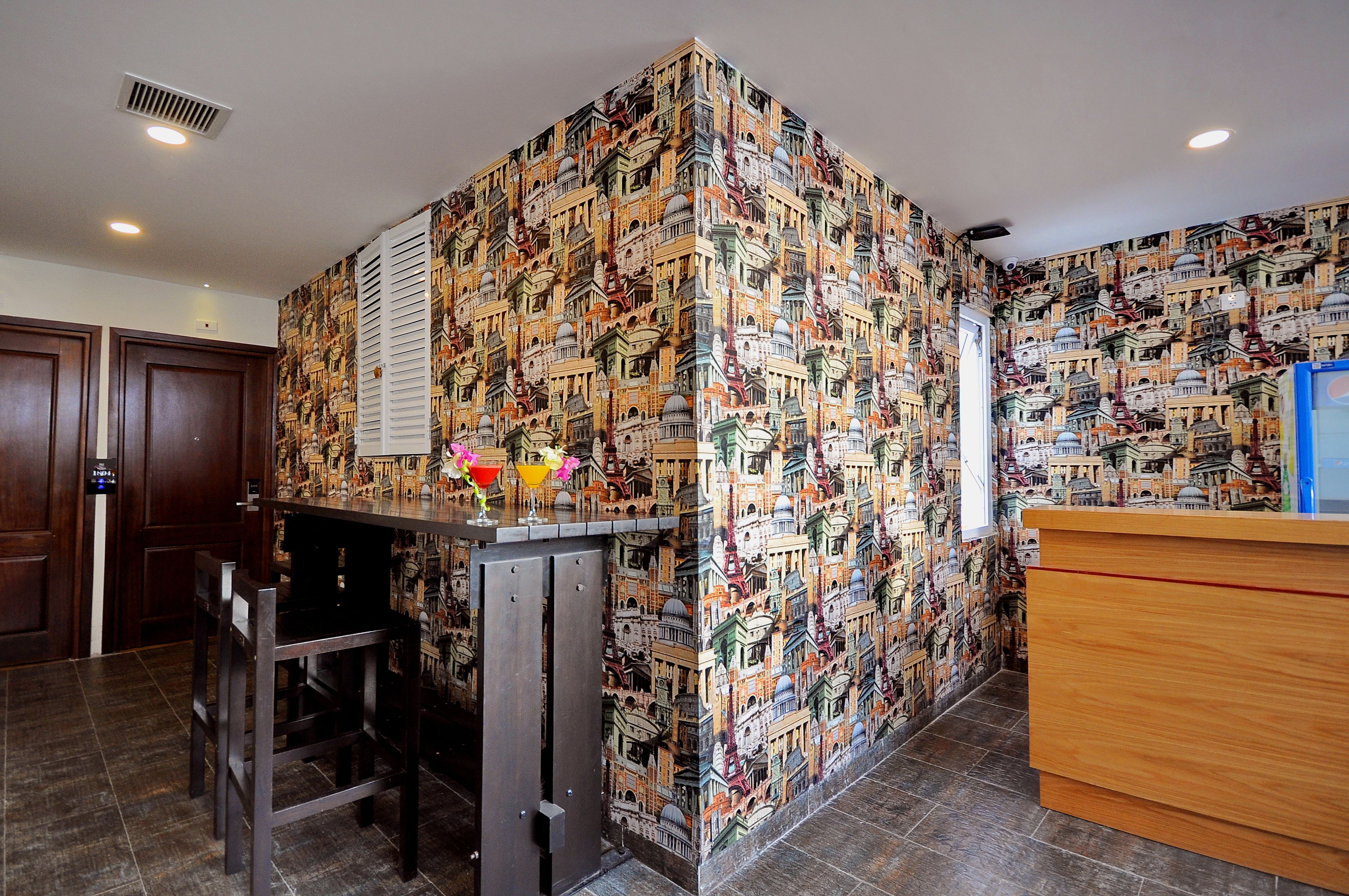Un hall de hotel con papel tapiz estampado, una recepción y una zona de bar.