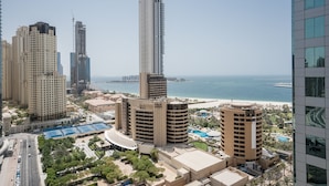 Un hotel de gran altura con múltiples pisos, vista a la playa y zona de piscina.