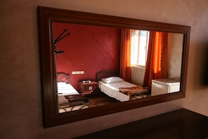 A bedroom with a bed, bedside table, and a dresser.