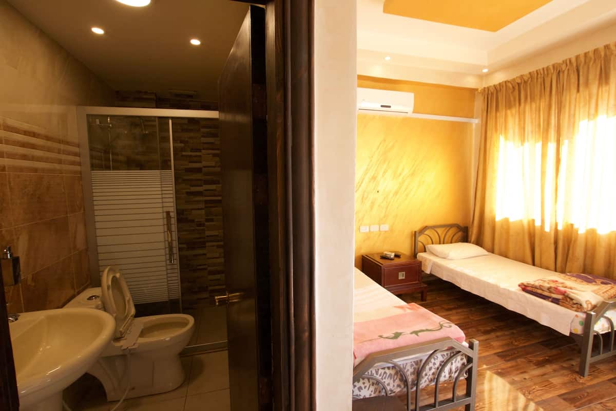 A bathroom with a shower, toilet, and bidet.