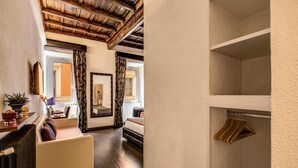 A room with a wooden ceiling, a bed, a mirror, and a coat rack. - Piazza di Spagna Comfort Rooms (Rome)