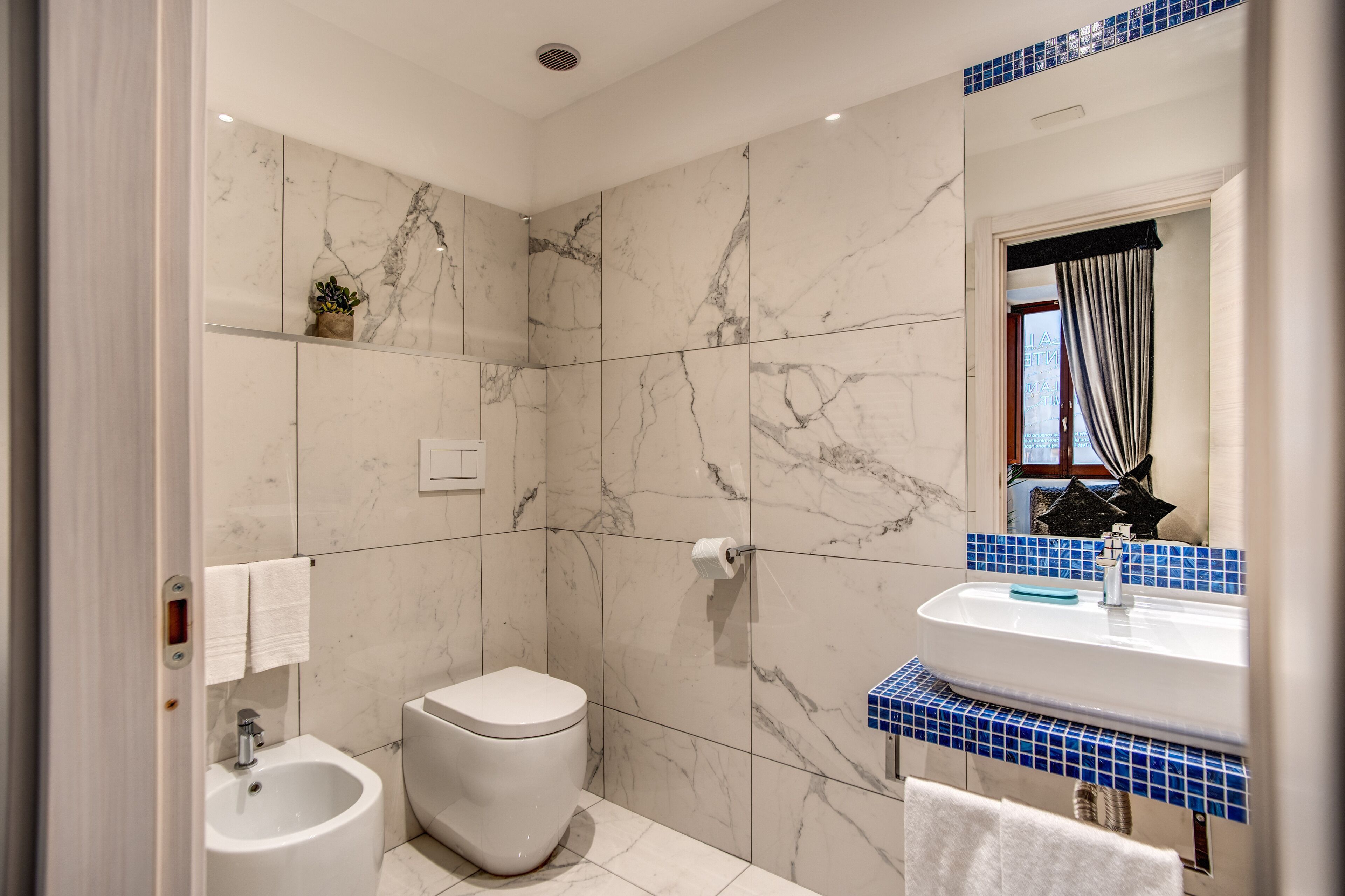 A modern bathroom with a toilet, bidet, and sink.