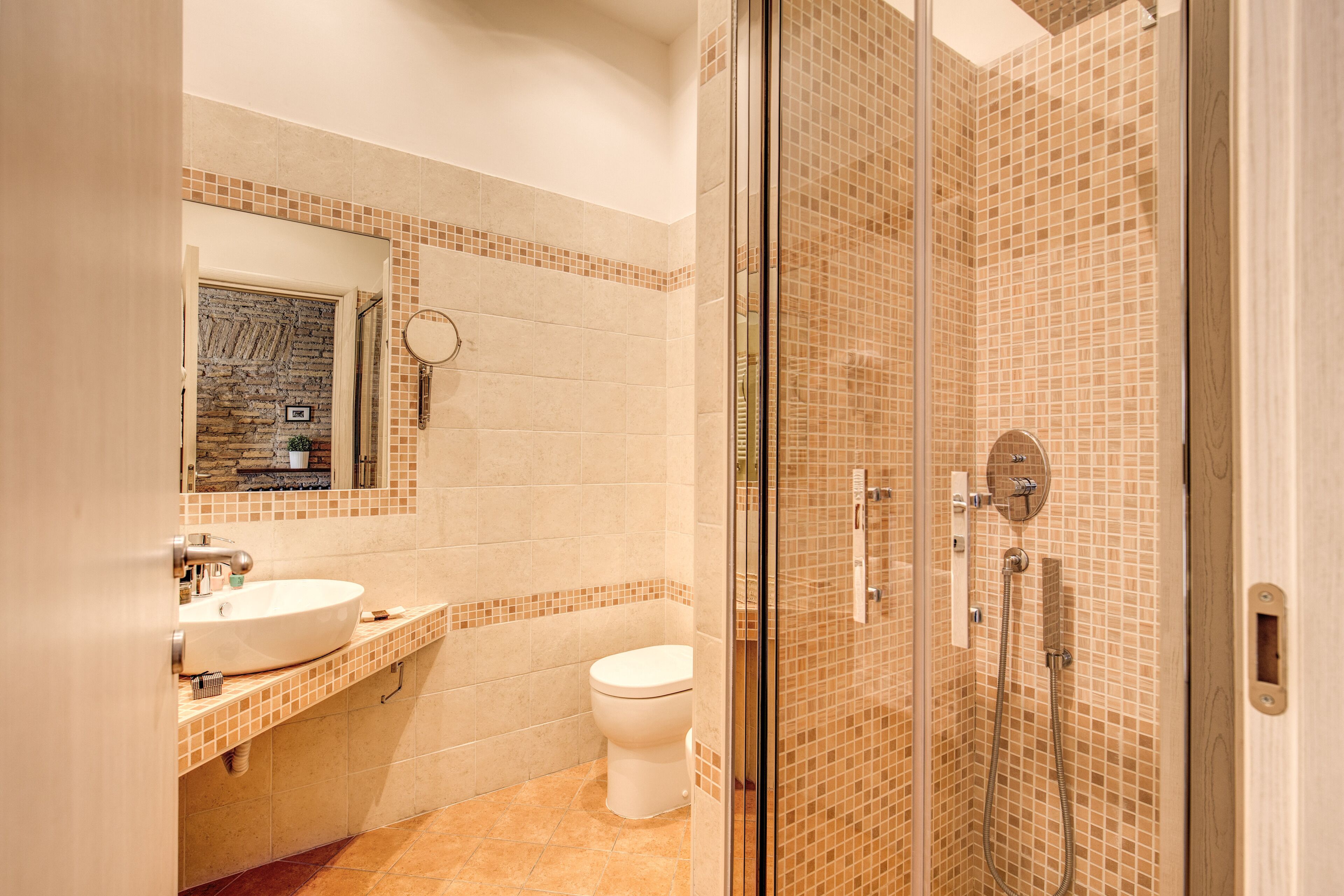 A bathroom with a sink, toilet, and glass-enclosed shower area.