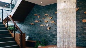 A staircase with wooden railings and a dark wall with fish-shaped decorations. - Adagio Shitiping (Fengbin)