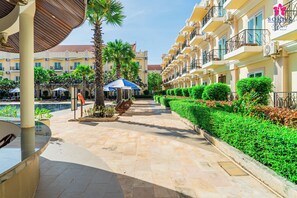 Una piscina al aire libre, sombrillas, sillones reclinables de piscina
