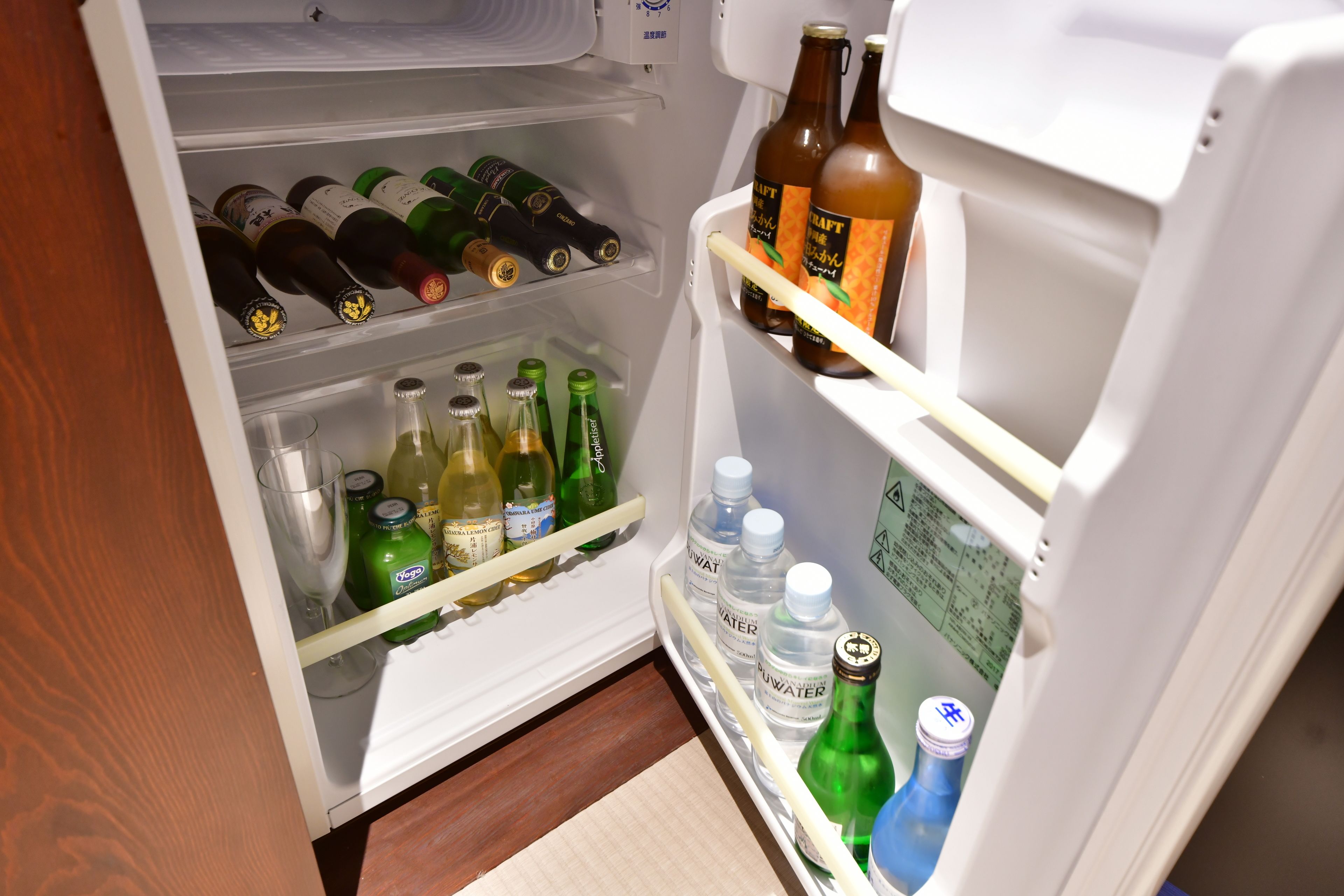 A refrigerator stocked with various beverages including beer, water, and wine.