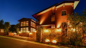 A modern two-story building with large windows and a stone wall. - Hakone Airu (Hakone)