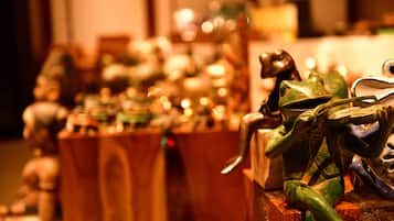 Una colección de figuritas de cerámica de ranas exhibidas sobre pedestales de madera.