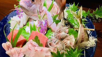 A seafood platter with various fish and garnishes on a blue plate.