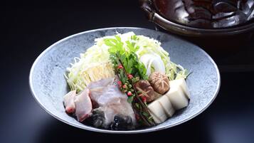 A bowl of assorted raw seafood and vegetables on a plate.