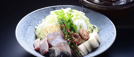 A bowl of assorted raw seafood and vegetables on a plate.