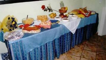 Una mesa de bufé con diversos alimentos y un centro de mesa floral.