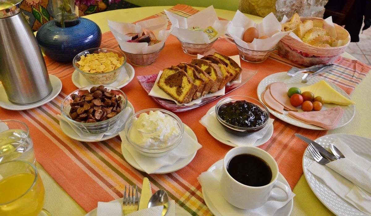 A breakfast table with various food items, including bread, eggs, cheese, and coffee.