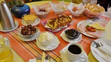 A breakfast table with various food items, including bread, eggs, cheese, and coffee.