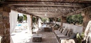 An outdoor patio with stone seating, a pool, and a pergola structure. - Sorelle Barnaba (Monopoli)