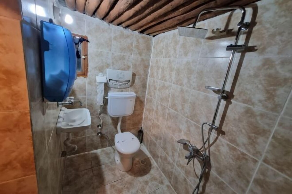 A bathroom with a toilet, sink, and shower.