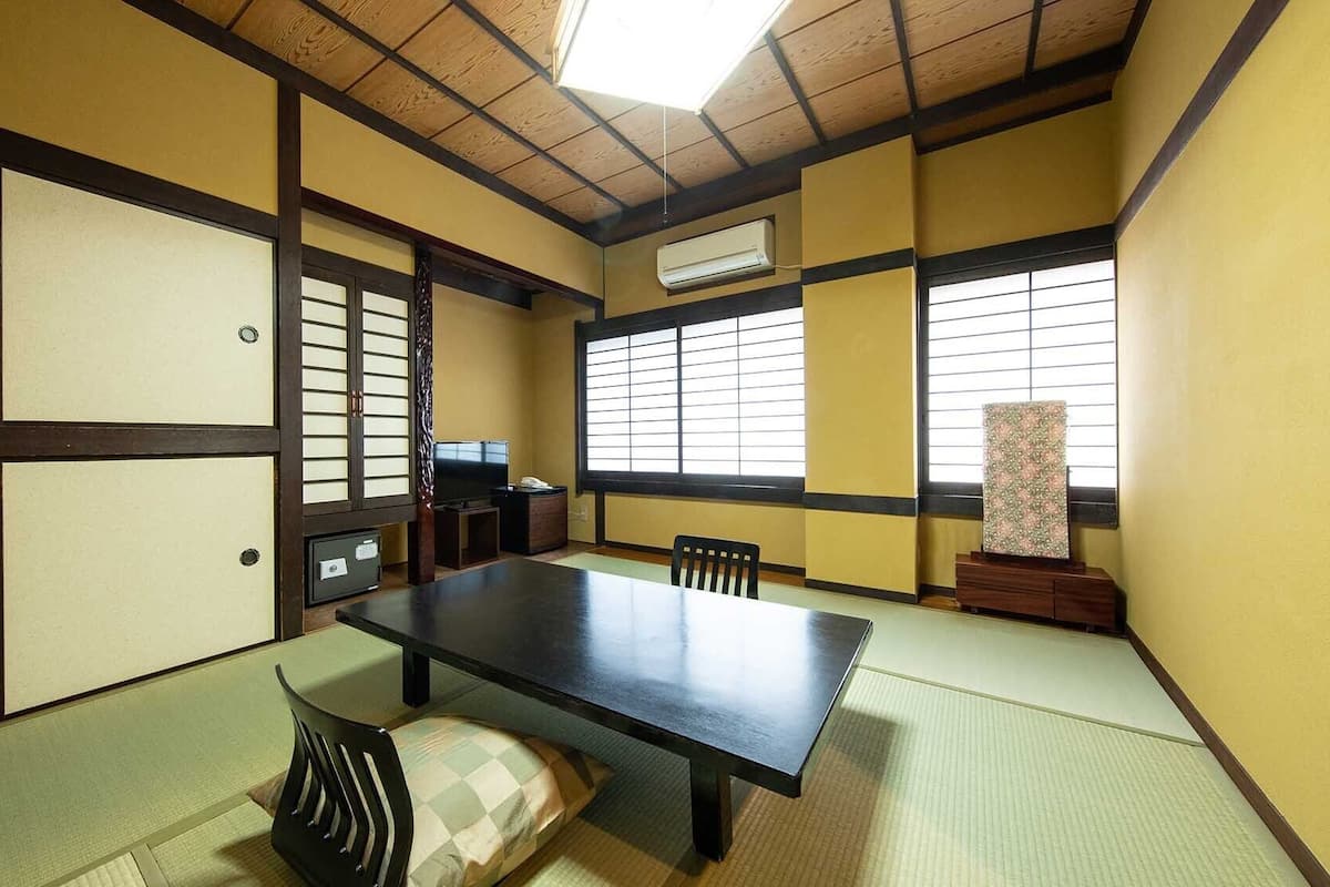 A traditional Japanese room with tatami flooring, a low table, and shoji screens.