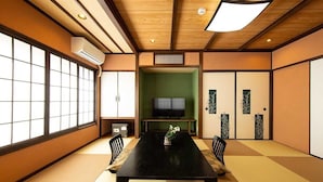 Una habitación tradicional japonesa con suelo de tatami, una mesa baja y puertas correderas.