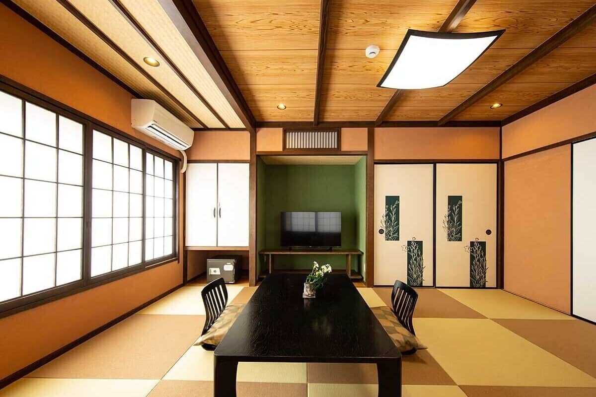 A traditional Japanese-style room with tatami flooring, a low table, and sliding doors.