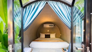 A cozy, tent-like room with a bed, curtains, and a small bedside table. - White Rabbit Hostel - Adults Only (Siem Reap)