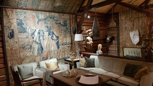 Una habitación acogedora con un tapiz grande, muebles de madera y una decoración rústica.