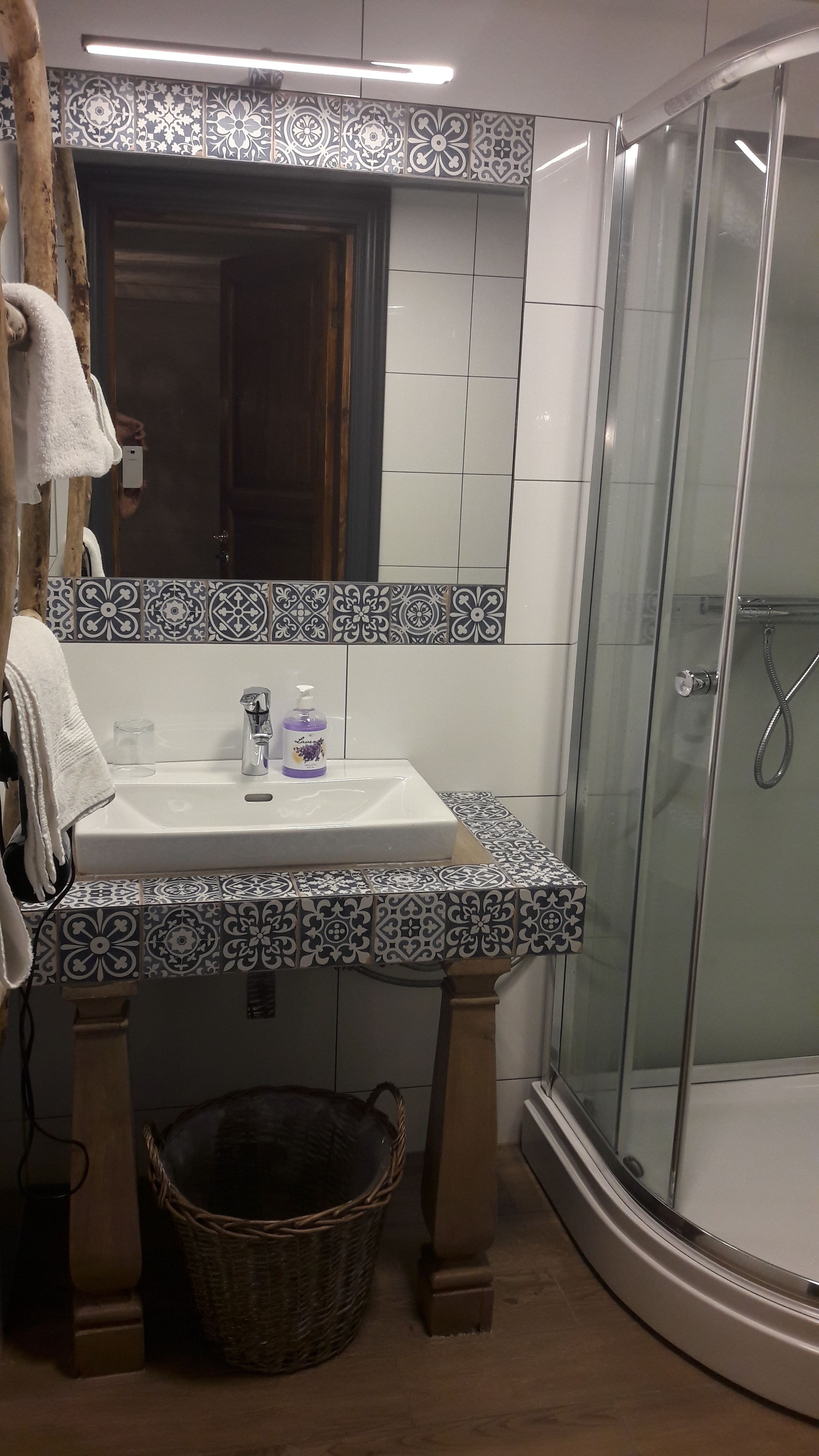 Un baño con lavamanos, espejo y ducha.