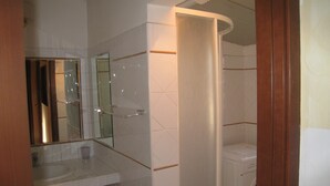 A bathroom with a shower, a sink, and a mirror. - Residenza Camilla (Rome)