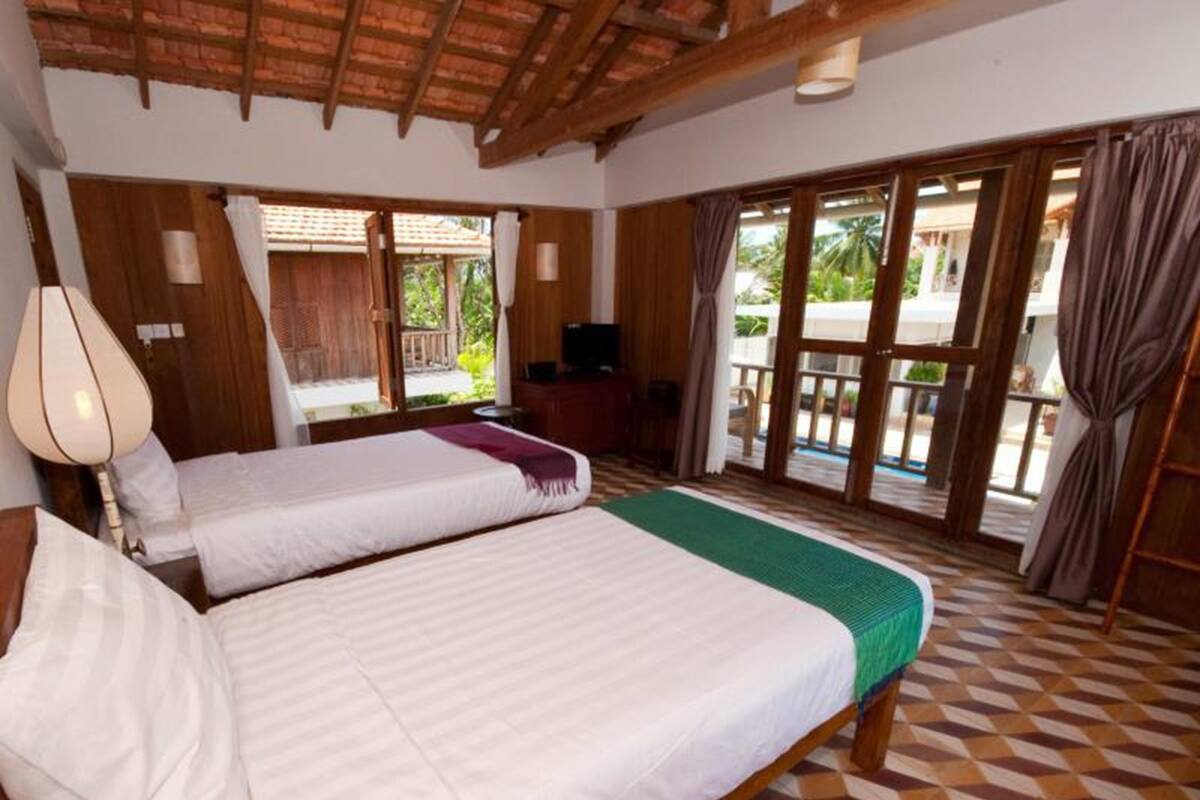 Una habitación con dos camas, televisión y vistas al exterior.
