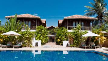Een buitenzwembad, parasols voor strand/zwembad