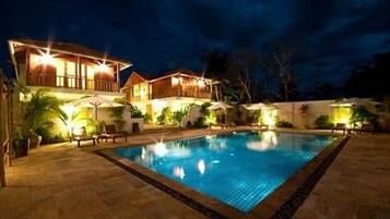 Een buitenzwembad, parasols voor strand/zwembad