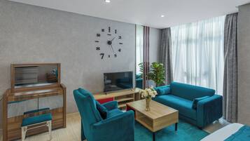 Una sala de estar moderna con un sofá, una mesa de centro, un televisor y un escritorio con cajones.