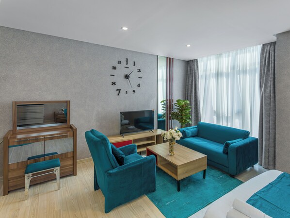 A modern living room with a sofa, a coffee table, a TV, and a desk with drawers.